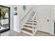Staircase near the front door with wood treads and white risers, illuminated by a stained glass window at 144 Jupiter Ln, Summerville, SC 29483