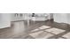 Open-concept living area with wood flooring, white walls, and a seamless transition to the kitchen area at 145 Threaded Fern St, Summerville, SC 29485