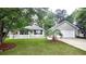 Charming home with a well-manicured lawn, white picket fence, and attached garage at 148 Jupiter Ln, Summerville, SC 29483