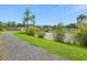 Community pond featuring trees and foliage, accessible via a gravel path; perfect for a serene stroll at 161 Brittondale Rd, Summerville, SC 29485