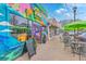 Vibrant storefront of Bonita Colombian Street Food cafe with ample outdoor seating and lush foliage at 1656 Indy Dr, North Charleston, SC 29405