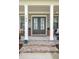 Charming front porch with brick steps, columns, double doors, a swing and cozy seating area at 184 Clearblue Loop, Summerville, SC 29486