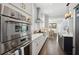A gourmet kitchen featuring stainless steel appliances, white cabinets, and hardwood floors leads into a dining area at 184 Clearblue Loop, Summerville, SC 29486