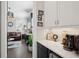 An open-concept kitchen with black and white cabinetry flows into a living room with a plush leather sofa at 184 Clearblue Loop, Summerville, SC 29486