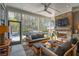 Relaxing screened-in porch boasts a brick fireplace, TV, and comfortable seating overlooking pool at 184 Clearblue Loop, Summerville, SC 29486