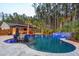 A luxurious backyard pool area with a built-in bar, ample seating, and lush greenery, ideal for relaxation and entertainment at 184 Clearblue Loop, Summerville, SC 29486