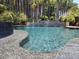 Beautiful in-ground pool surrounded by lush landscaping and a decorative stone waterfall feature at 184 Clearblue Loop, Summerville, SC 29486