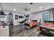 Spacious bedroom features gray wood floors, ceiling fan, hammock, and Chiefs-themed beds and accessories at 2004 Hammond Dr, Mount Pleasant, SC 29466