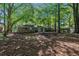 Expansive backyard with mature trees, brick house and patio offering privacy and natural beauty at 203 Elliott Dr, Ladson, SC 29456