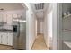 Hallway view with tile floors and access to the kitchen with stainless steel refrigerator and pantry shelving at 203 Elliott Dr, Ladson, SC 29456