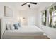 Bright bedroom featuring a plush queen bed, a ceiling fan, and a large window at 217 E Huron Ave, Folly Beach, SC 29439