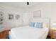 A comfortable bedroom features a white wooden bed, blue pillows, and a large window at 217 E Huron Ave, Folly Beach, SC 29439