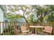 Outdoor deck area with seating overlooking a wooded area with other homes in the background at 217 E Huron Ave, Folly Beach, SC 29439