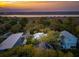 Exterior view of home with solar panels, surrounded by lush greenery and nearby river at 217 E Huron Ave, Folly Beach, SC 29439