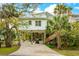 Charming stilt home with palm trees and long driveway for easy access and parking at 217 E Huron Ave, Folly Beach, SC 29439