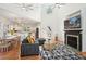 Bright living room featuring a fireplace, high ceilings, modern decor, and an open layout to the kitchen and dining area at 217 E Huron Ave, Folly Beach, SC 29439