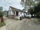 Single-story home with a brick foundation, white siding, covered front porch, and an expansive driveway at 227 Fishburne St, Charleston, SC 29403