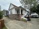 Single-story home with a brick foundation, white siding, covered front porch, and an expansive driveway at 227 Fishburne St, Charleston, SC 29403