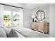 Comfortable bedroom with neutral tones, natural light, a dresser with a round mirror, and stylish decor at 257 Camellia Bloom Dr, Moncks Corner, SC 29461