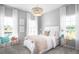 Bright bedroom featuring stylish chandelier, white bedding, and large windows providing natural light at 265 Camellia Bloom Dr, Moncks Corner, SC 29461