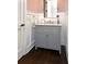 Elegant powder room with granite countertop, gray vanity, white wainscoting and luxury fixtures at 2805 Stay Sail Way, Mount Pleasant, SC 29466