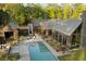 Aerial view of a modern home with angular roof, pool, patio, and wooded landscape at 2885 Plow Ground Rd, Johns Island, SC 29455