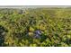 Distant aerial view of modern home nestled into a dense forest, with pool, and access road at 2885 Plow Ground Rd, Johns Island, SC 29455
