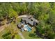 Aerial view of a modern home with distinct architecture, a private pool, surrounded by lush trees and green grass at 2885 Plow Ground Rd, Johns Island, SC 29455
