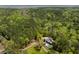 Expansive aerial view of a modern home, pool and lush forest, set against the backdrop of a distant river at 2885 Plow Ground Rd, Johns Island, SC 29455