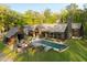 Aerial view of a modern home featuring an angular roof, pool, patio, and wooded lot at 2885 Plow Ground Rd, Johns Island, SC 29455