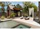 The backyard oasis includes a pool, lounge area, and fireplace for entertaining or relaxing in style at 2885 Plow Ground Rd, Johns Island, SC 29455