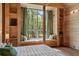 Bedroom view of a light-filled window seat with verdant views, pillows, and wood paneled walls at 2885 Plow Ground Rd, Johns Island, SC 29455