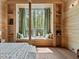 Bedroom showcasing a large window with window seats and built-in shelves, complemented by wood paneled walls at 2885 Plow Ground Rd, Johns Island, SC 29455