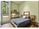 This bedroom features a cozy bed, built-in shelves and a great view into the forest at 2885 Plow Ground Rd, Johns Island, SC 29455