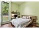 Bedroom featuring a large window, built-in shelves, and hardwood floors, offering a cozy retreat at 2885 Plow Ground Rd, Johns Island, SC 29455
