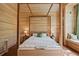 Light-filled bedroom with wood-paneled walls, canopy bed, bedside tables, and a window seat with verdant views at 2885 Plow Ground Rd, Johns Island, SC 29455
