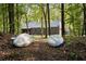 The house is nestled in the trees with two kayaks on the ground out front; a serene woodland retreat at 2885 Plow Ground Rd, Johns Island, SC 29455