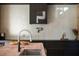 Modern kitchen featuring dark wood cabinets, sleek countertops, and a stylish pot filler faucet at 2885 Plow Ground Rd, Johns Island, SC 29455