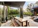 Beautiful outdoor dining area featuring a large wooden table, benches, and views of the pool and lush greenery at 2885 Plow Ground Rd, Johns Island, SC 29455