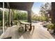 Spacious outdoor dining area on a wooden deck, offering serene views of the pool and well-manicured backyard at 2885 Plow Ground Rd, Johns Island, SC 29455