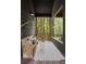 Cozy screened-in patio with comfortable seating, throw pillows, and scenic view of the surrounding woods at 2885 Plow Ground Rd, Johns Island, SC 29455