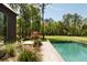 An inviting pool merges with lush landscaping for serene relaxation, complemented by sleek home design and natural beauty at 2885 Plow Ground Rd, Johns Island, SC 29455