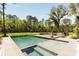 A luxurious pool with a spa and lush landscaping creates a serene backyard oasis, perfect for relaxation and entertainment at 2885 Plow Ground Rd, Johns Island, SC 29455