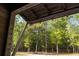 Covered porch view showcases a sprawling wooded landscape, emphasizing the home's integration with nature at 2885 Plow Ground Rd, Johns Island, SC 29455