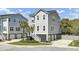 Three-story gray home with a private driveway, lush landscaping, and beautiful curb appeal at 2928 Tranquility Rd, Mount Pleasant, SC 29466