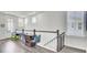 Bright hallway with hardwood floors and white railing leads to a door and features an arcade game at 2928 Tranquility Rd, Mount Pleasant, SC 29466