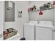Functional laundry room with white appliances and shelving for organized storage and a whimsical cat portrait at 2928 Tranquility Rd, Mount Pleasant, SC 29466