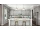 Bright kitchen with white cabinets, stainless steel appliances, a large island with stool seating, and modern lighting at 299 Citrus Dr, Summerville, SC 29486