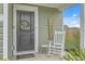 Inviting front door with a seasonal wreath, welcome sign, and rocking chair at 302 Fox Gap Rd, Summerville, SC 29486