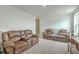 Open living room with brown leather couches, neutral carpeting and bright window at 302 Fox Gap Rd, Summerville, SC 29486